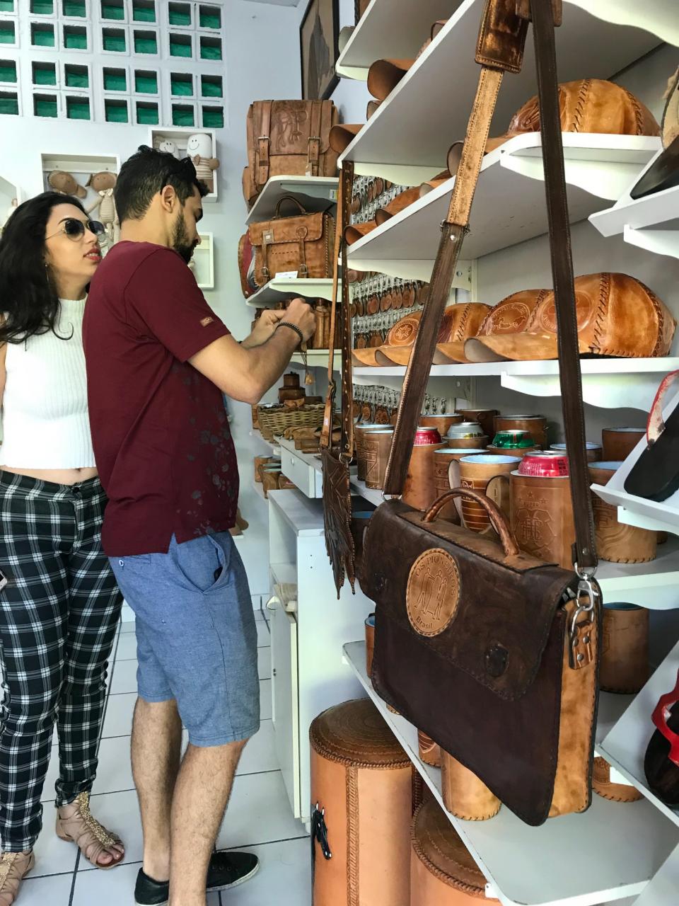 Turistas visitando os produtos de couro do Chalé 51 de João Batista